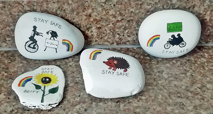 4 stones painted with a unicyclist, a sunflower, a tandem, a hedgehog